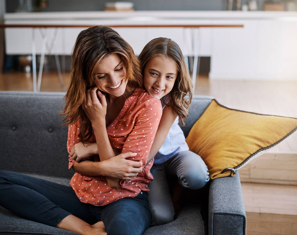 Pouto mezi matkou a dcerou. atraktivní mladá žena a její dcera objímání při trávení času spolu doma - Fotografie, Obrázek