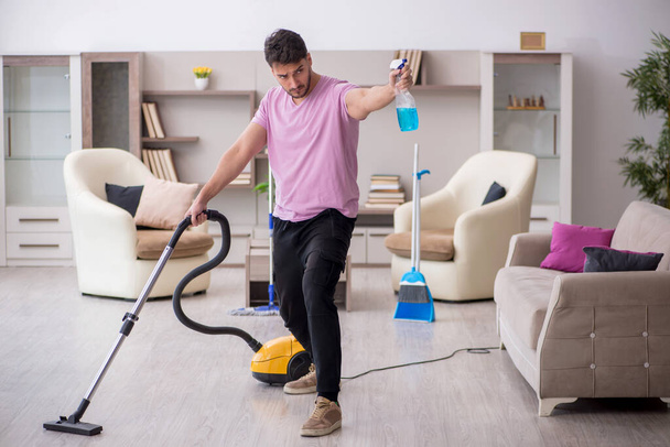 Giovane imprenditore pulizia della casa - Foto, immagini