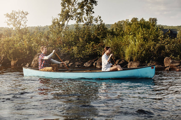 Gehen Sie dahin, wo der Fluss fließt. Ein junges Paar auf Kanutour auf dem See - Foto, Bild