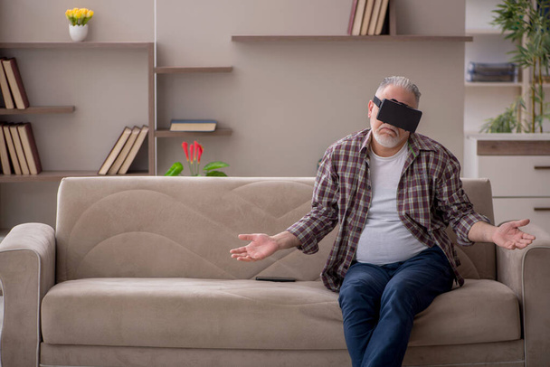 Old man enjoying virtual glasses at home - Foto, afbeelding