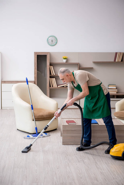 Vecchio imprenditore pulizia della casa - Foto, immagini