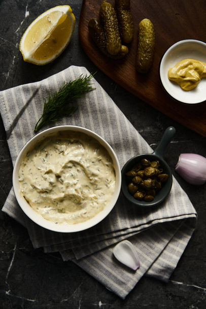 Classic Tartar Sauce with it ingredients on dark stone or marble background. Mayonnaise with dill and pickled cucumbers with lemon. High quality photo - Photo, image