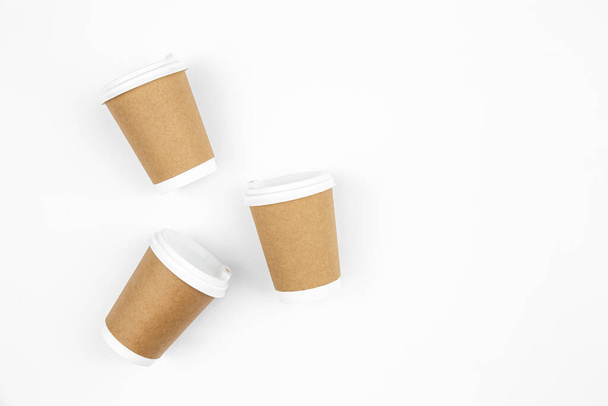 Disposable craft paper cups on a white background, top view, copy space. - Zdjęcie, obraz