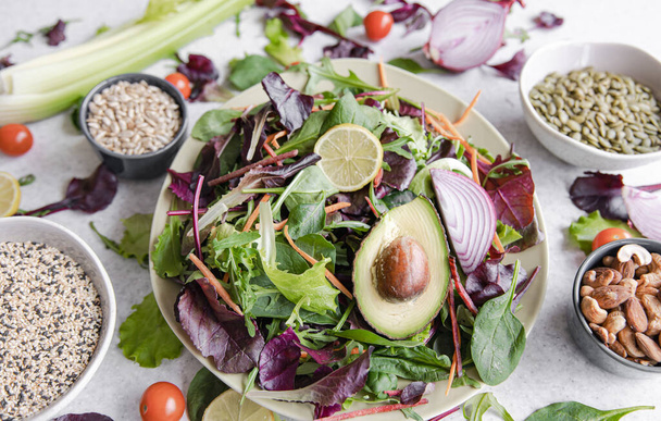 Salát z avokáda a zeleniny míchané listy salátu připravené k jídlu, zblízka, zdravé ruční vegetariánské jídlo. - Fotografie, Obrázek