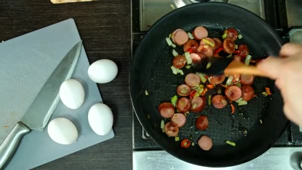 pohled shora na smaženou klobásu s cibulí a domácí kuchyní z červené papriky - Záběry, video