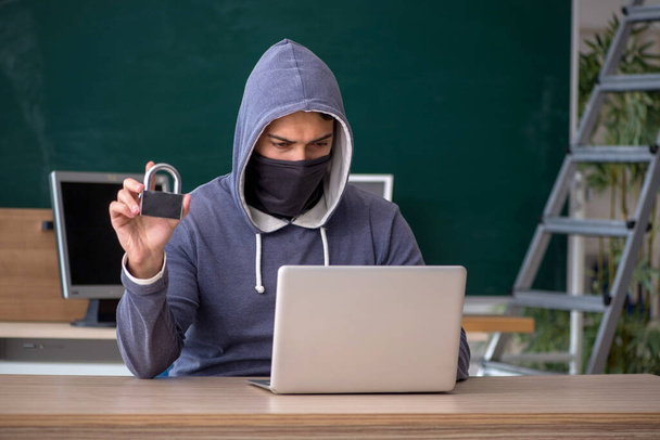 Молодой хакер сидит в классе - Фото, изображение