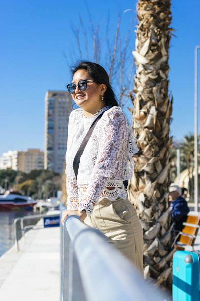 Smiling Asian Businesswoman in Suit with Harbor in the Background - Foto, afbeelding