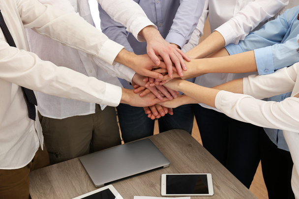 United hands of business team on workspace background - Photo, Image