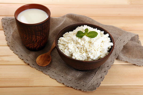 Cottage cheese in bowl with cup of milk on wooden background - Φωτογραφία, εικόνα