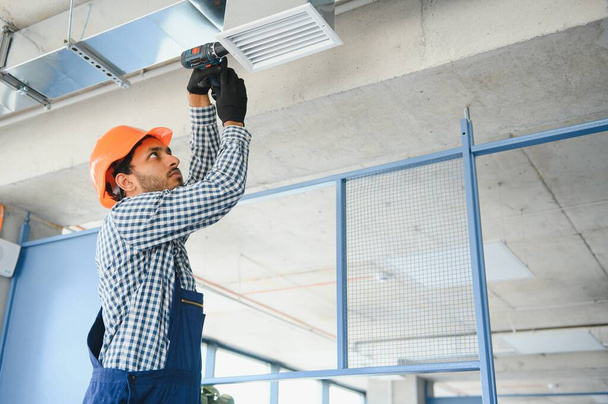 Ventilation cleaning. Specialist at work. Repair ventilation system (HVAC). Industrial background. - Фото, изображение