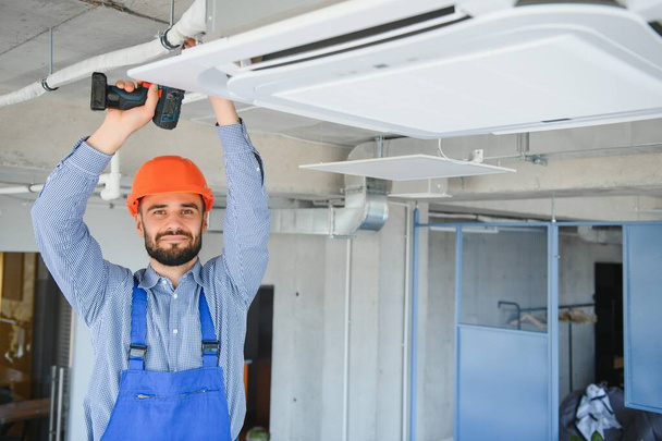 technician service checking and repairing air conditioner indoors. - Foto, afbeelding