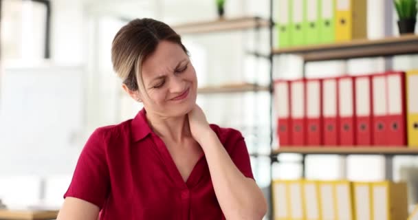 Zmęczona pracownica cierpi na ból szyi w miejscu pracy w nowoczesnym biurze firmy. Wpływ przepracowania na zdrowie kobiet w zwolnionym tempie - Materiał filmowy, wideo