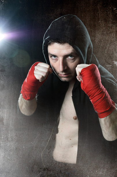 Homem de boxe com capuz jumper com capuz na cabeça com as mãos embrulhadas pulsos prontos para lutar
 - Foto, Imagem