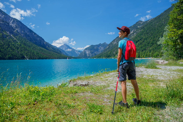 Hiker in the Alps. Boy backpacker tourist hiking at Lake. Alps, Bavaria, Germany - Fotó, kép