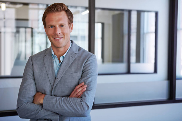 Confidence leads to success. Cropped portrait of a businessman standing with his arms folded in his office - Foto, Bild