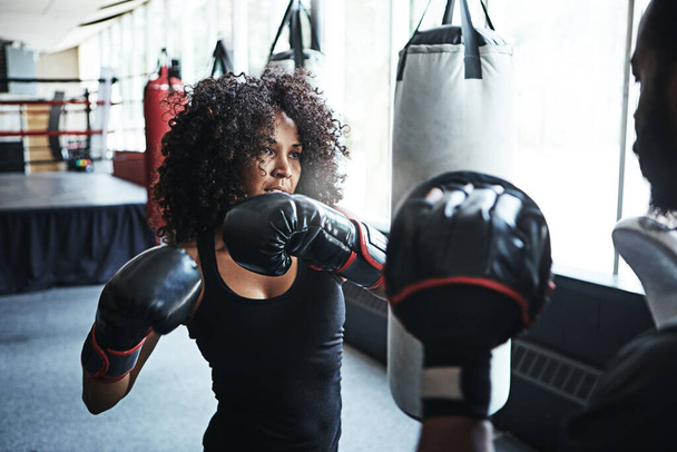 Every move you make starts with your heart. a female boxer practising her moves with her coach - Photo, Image