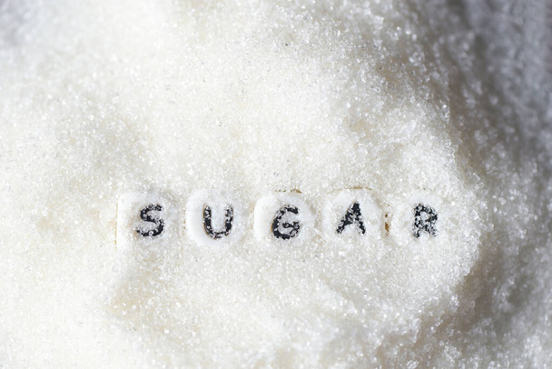 montón de azúcar en el fondo, azúcar blanca para alimentos y dulces postre caramelo montón de azúcar dulce granulado cristalino - vista superior - Foto, Imagen
