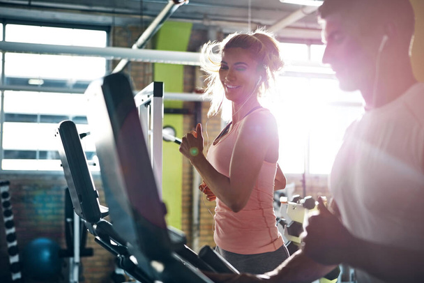 Siéntase orgulloso de cada paso que dé hacia su meta. un hombre y una mujer haciendo ejercicio juntos en el gimnasio - Foto, imagen