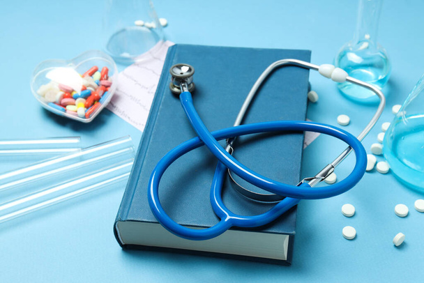 Literatura médica - livro e acessórios médicos sobre fundo azul - Foto, Imagem