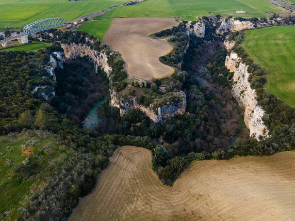 wąwozy rzeki Gravina, kaniony wyrzeźbione w skale z polami uprawnymi wokół - Zdjęcie, obraz