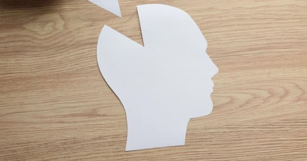 Ruka ženy vloží chybějící kus do trojúhelníkového papíru v oblasti mozku lidské hlavy. Chybějící prvek jako psychologický koncept myšlení - Záběry, video