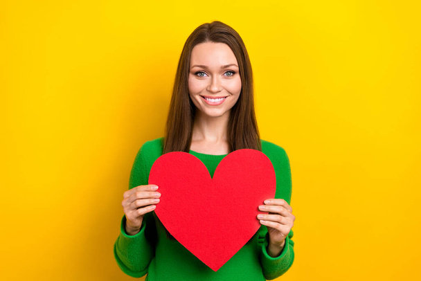 Photo of pretty cute lady dressed green pullover holding big red heart isolated yellow color background. - Фото, зображення