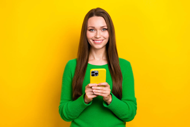 Φωτογραφία από χαρούμενα όμορφη γυναίκα φορούν πράσινο πουλόβερ κουβέντα twitter τηλεγράφημα facebook απομονωμένο κίτρινο χρώμα φόντο. - Φωτογραφία, εικόνα
