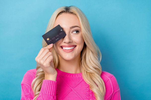 Photo of dreamy sweet lady wear pink sweater rising bank card close eye looking emtpy space isolated blue color background. - Φωτογραφία, εικόνα