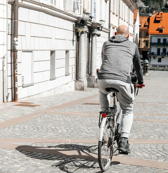 Komean hipsterimiehen muotokuva. Mies suuressa kaupungissa pyöräilemässä polkupyörällä. Elämäntyylin konsepti. - Valokuva, kuva
