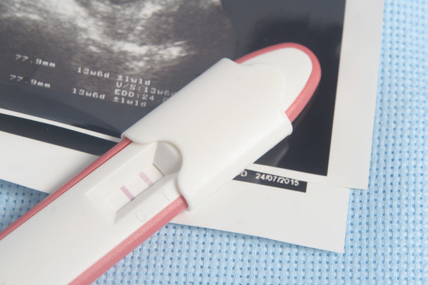 Pacote de teste de gravidez em fundo vermelho escuro
 - Foto, Imagem