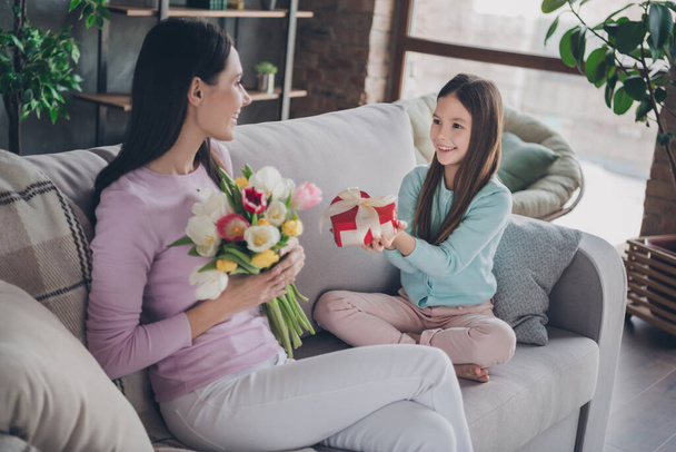 Photo of sweet cute mother daughter wear casual outfits giving heart shape gift box flowers indoors house room. - Foto, afbeelding
