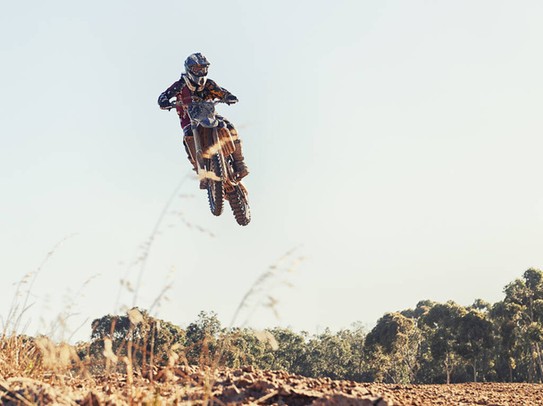 Szakadozik a levegőben. egy motocross versenyző ugrik át egy versenyen. - Fotó, kép