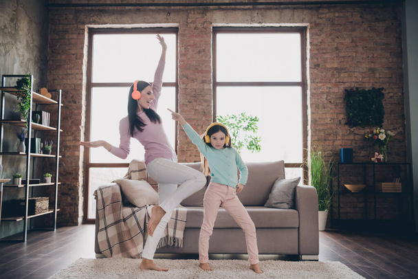 Full length photo of funny family active mom dynamic kid girl listen pop rock music dance on living room house. - Zdjęcie, obraz