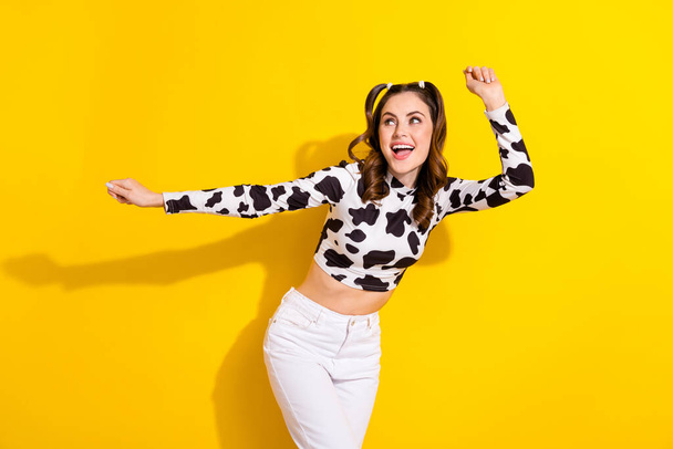Photo of sweet adorable lady dressed cowskin shirt smiling dancing having fun isolated yellow color background. - Photo, image