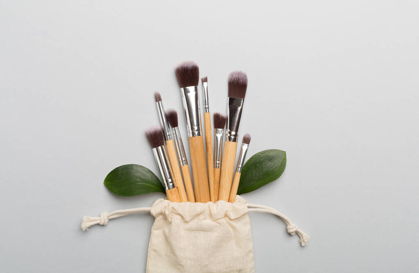 Natural biodegradable makeup brushes on color background, top view - Foto, afbeelding