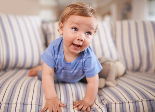 The cutest smile. an adorable little infant sitting on a sofa - 写真・画像