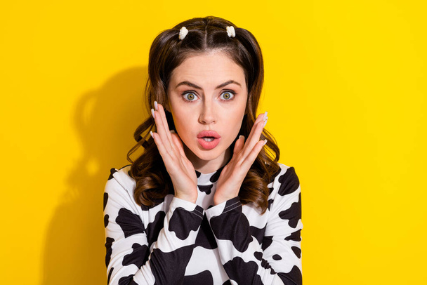 Portrait of charming young lady wear glamour stylish cowskin top palms cheeks unexpected scared isolated on yellow color background. - Фото, изображение