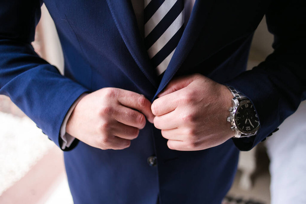 This captivating image showcases the groom's wedding attire, including his suit, shoes, and cufflinks, as he gets dressed for his big day. The photograph highlights the intricate details of the groom's ensemble, creating a beautiful composition that  - Foto, Bild