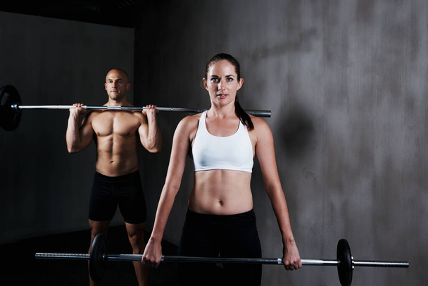 Training to become fighting fit. a man and woman working out with barbells - Photo, Image
