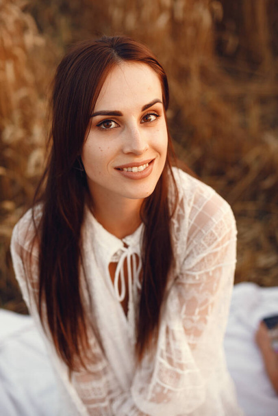 Beautiful girl in a white dress. Woman in a autumn wheat field. - Fotografie, Obrázek