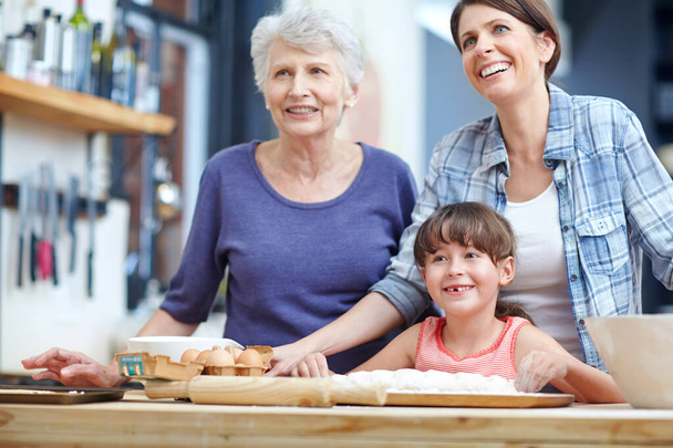 Hora de hornear unas galletas. una familia de tres generaciones horneando juntos - Foto, Imagen