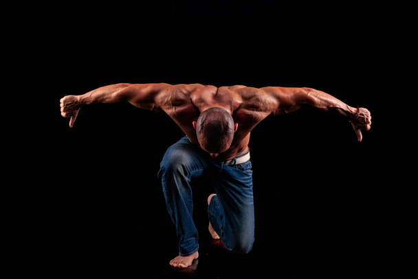 Athlete bodybuilder on a black background - Foto, Imagen