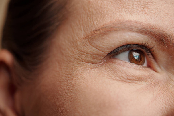 Rides oculaires de la femme d'âge moyen, soins de la peau et concept de thérapie rajeunissante - Photo, image