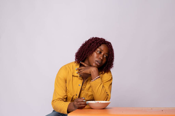 hungry black lady holding an empty plate and looking unhappy - Foto, Imagen