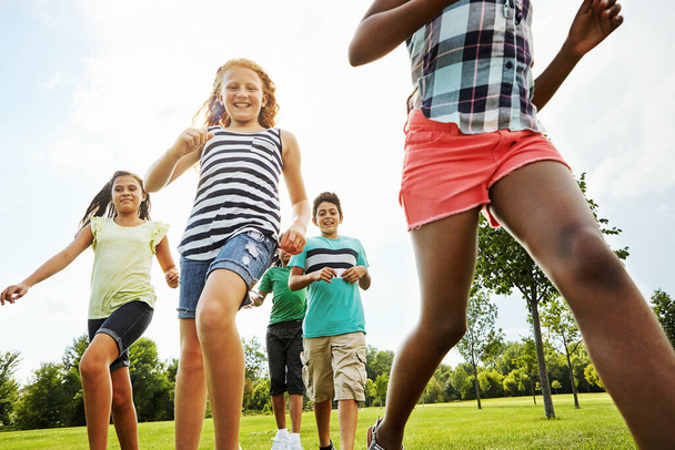 Race you to the end. a group of diverse and happy kids playing together outside - Foto, imagen