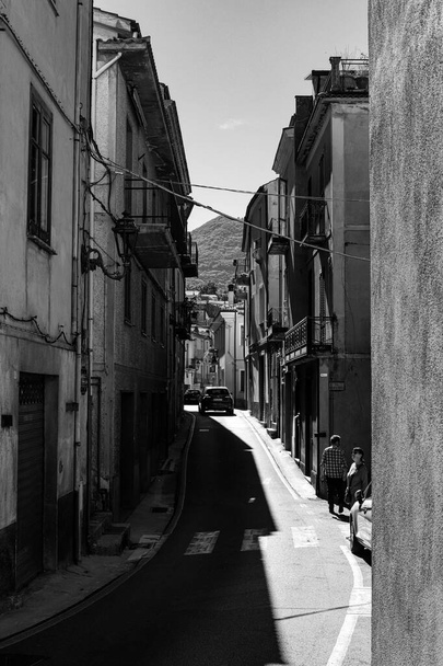 A vertical grayscale of a narrow street in the town and commune of Lauria in southern Italy - Fotografie, Obrázek