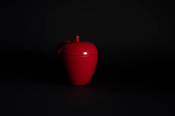 A red, apple-shaped candle isolated on black - Foto, Bild