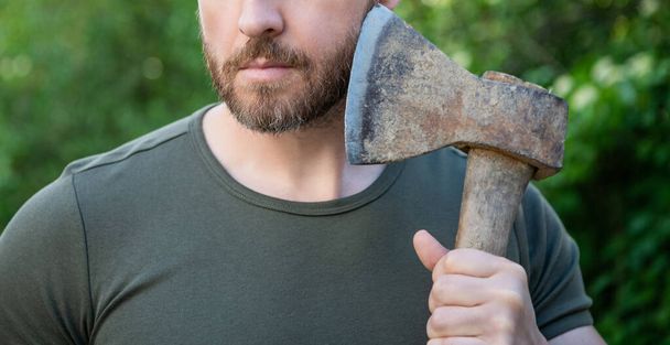 cropped photo of masculine guy with axe. masculine guy with axe. bearded masculine guy with axe. masculine guy with axe outdoor. - Φωτογραφία, εικόνα