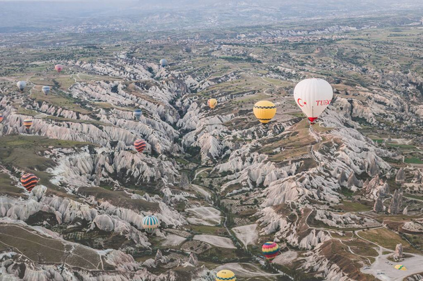 A beautiful shot of the hot air balloons over a landscape in the Cappadocia area in Turkey - Photo, Image