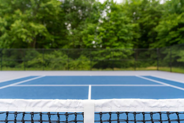 Amazing new blue tennis court with white lines and gray out of bounds - Foto, Bild